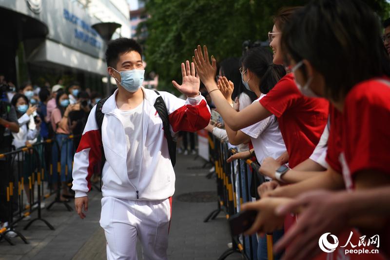 6月7日，2021年北京高考首日，在北京人大附中门口，考生有序进入考场，与送考亲友击掌打气。人民网记者 翁奇羽摄